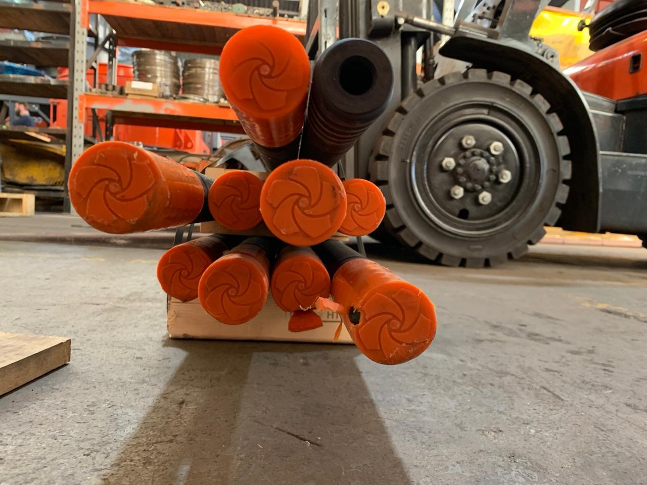 Drill rod bundle with orange couplings — end-on view ready for dispatch