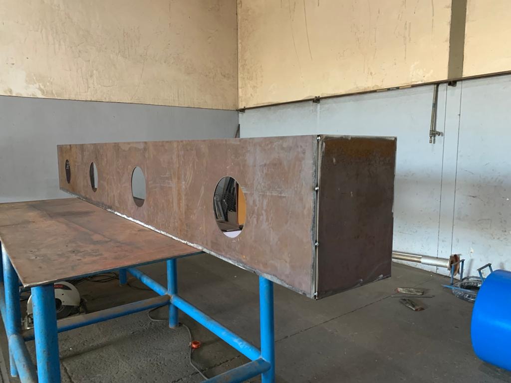 Long-side view — tack-welded mine workshop assembly